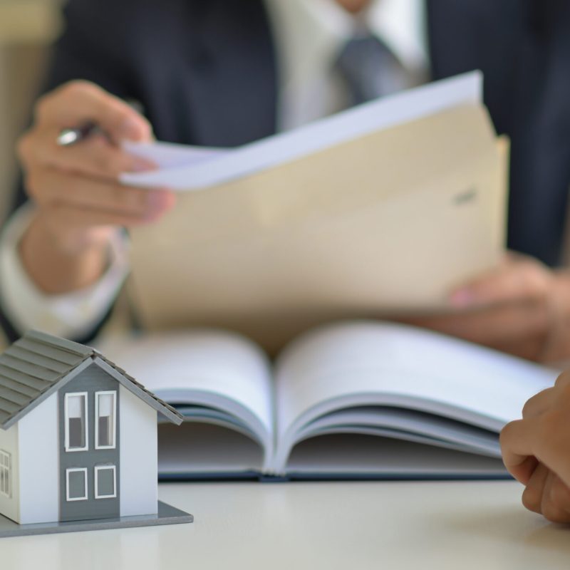 The lawyer is consulting clients about the house purchase contract.